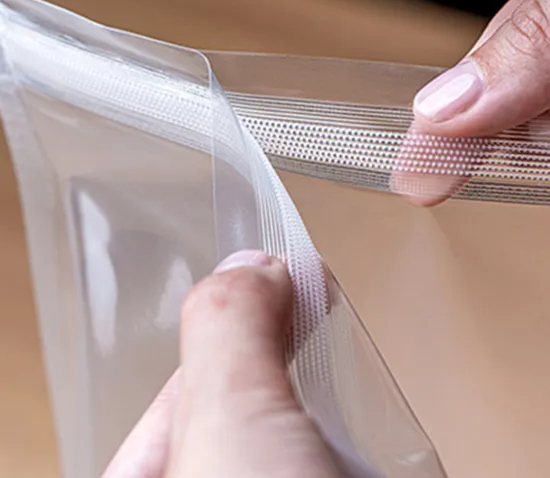 Hands opening a clear hook-to-hook zipper closure